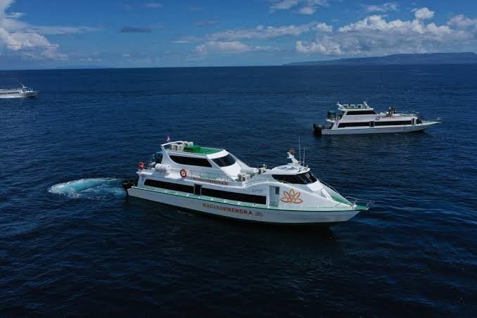 Speedboat on blue water with mountain background under blue sky with clouds